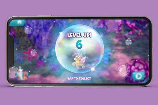 Phone screen displaying a game with a 'Level Up!' message in My Little Pony mobile game